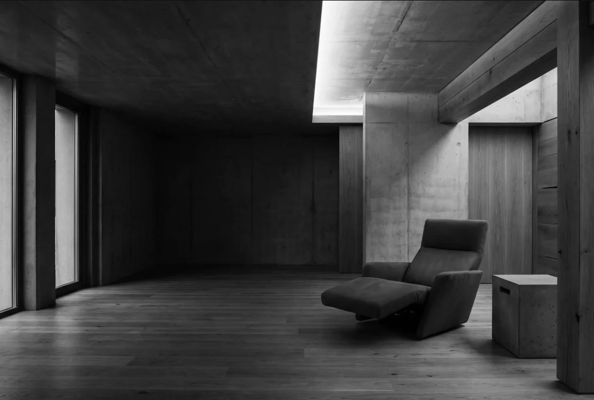 Ambiente sereno com chaise, luz natural e materiais de textura suave.